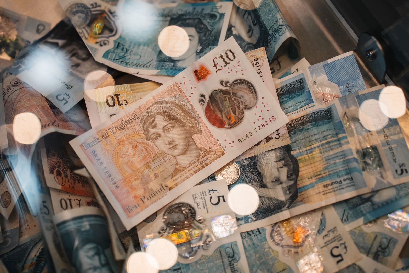 Sterling five and ten pound notes lying loose in an open cash drawer