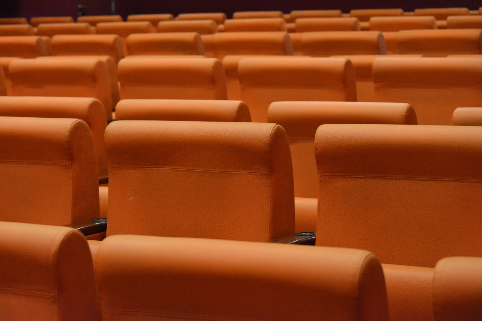 Rows of empty orange auditorium seats Rows of empty orange auditorium seats