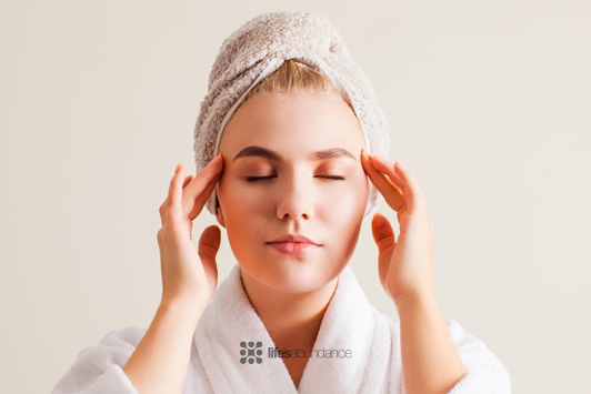 woman giving self facial massage