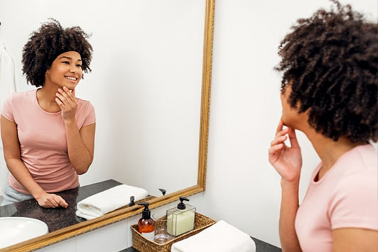 girl looking in mirror at clean face