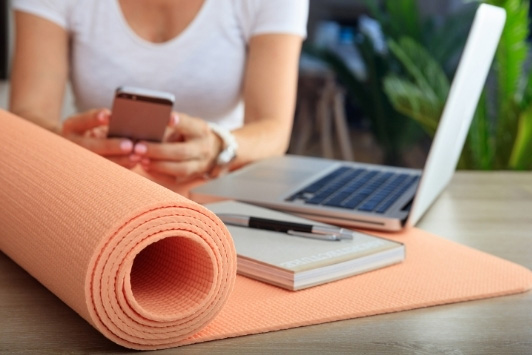 woman at desk with yoga mat
