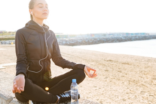 person listening to meditation on the beach