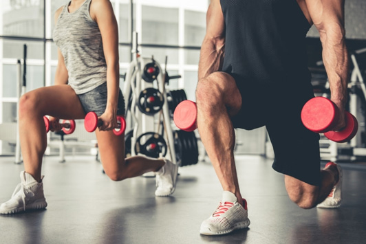 two people doing lunges at gym