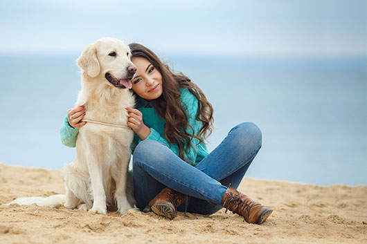 Woman With Healthy Dog At Beach