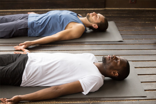 men doing savasana