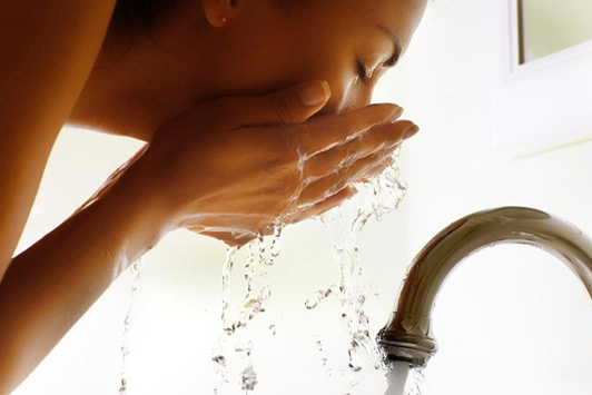 woman removing makeup at sink