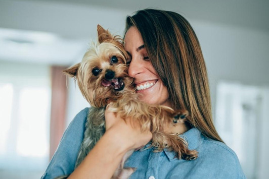 woman cuddling with dog