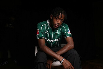 null Mbangula im Werder-Trikot auf einem Stuhl.