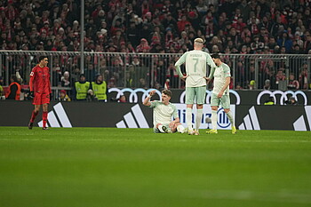 Jens Stage sitzt auf dem Boden im Werder Auswärtstrikot in der Allianz Arena