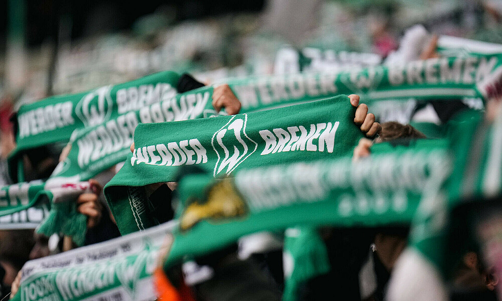 null Werder-Fans zeigen den Schal in der Kurve.