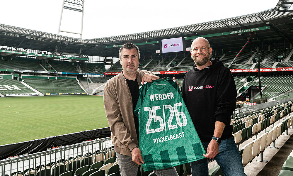 Hans-Jörg Otto und Philipp Preuße halten ein Trikot hoch.
