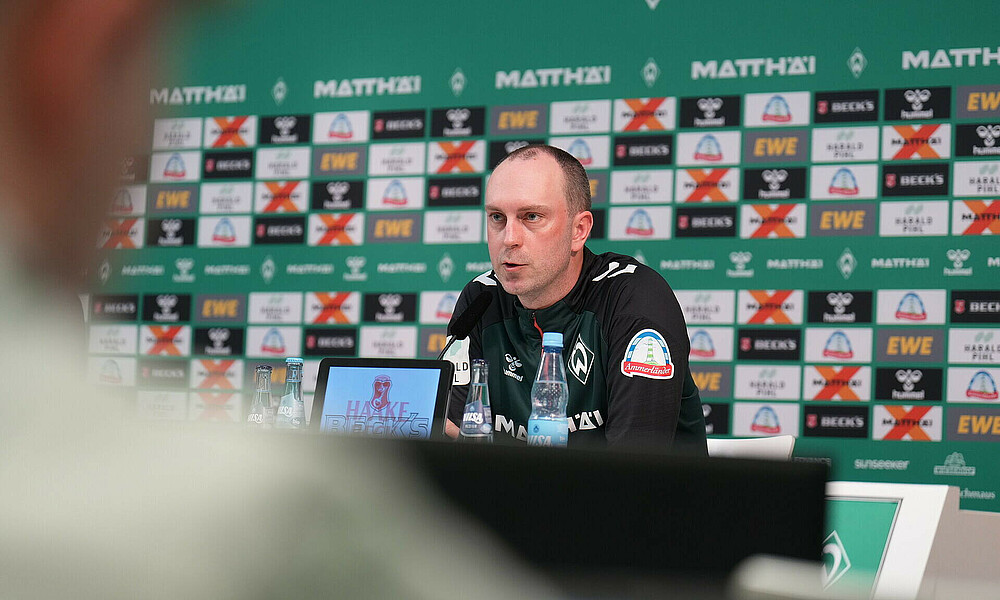 Cheftrainer Ole Werner auf dem Podium bei der Pressekonferenz