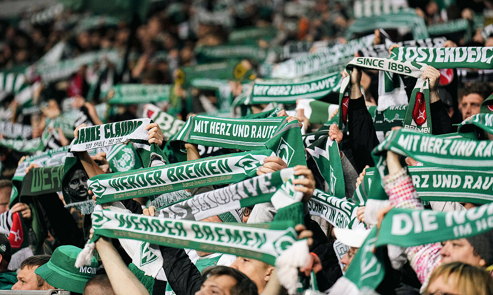 Hochgehaltene Fanschals im wohninvest WESERSTADION.