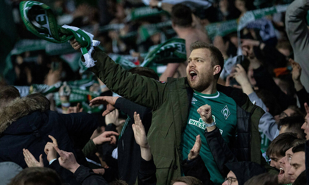 Ein Werder-Fan jubelt mit Schal