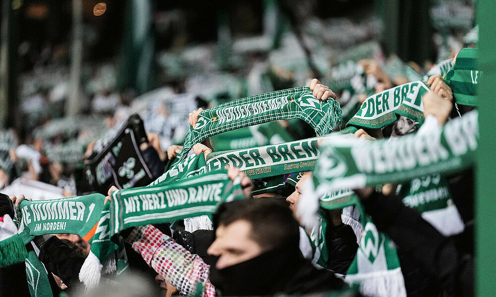 Die Werder-Fans halten den Schal hoch.