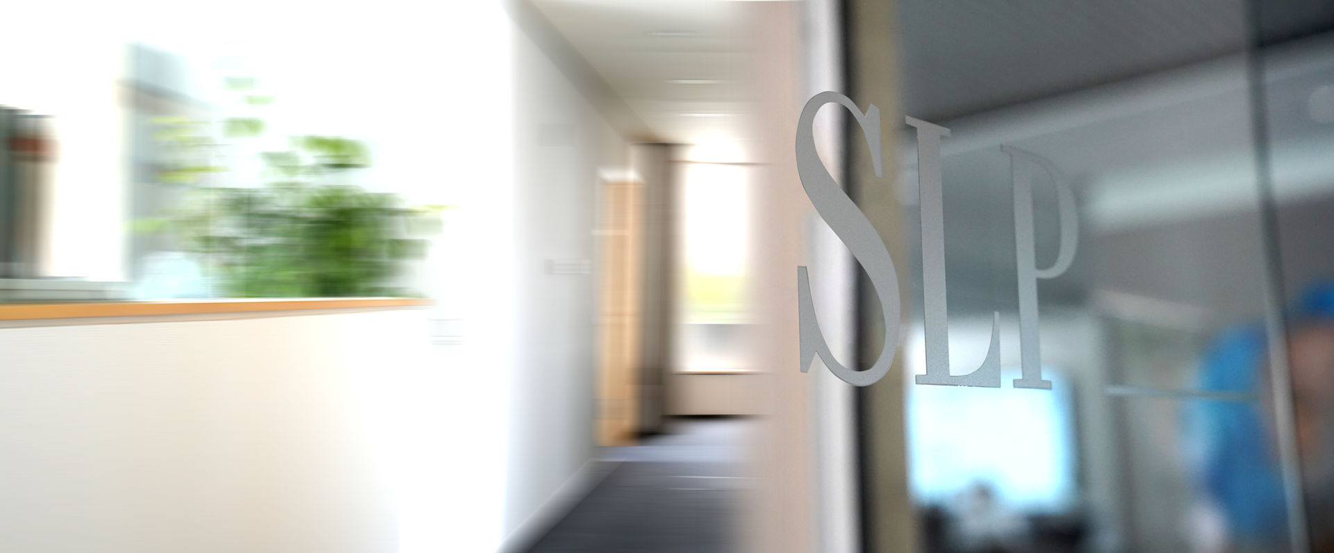 Nahaufnahme einer gläsernen Bürotür mit mattierten Buchstaben „SLP“, dahinter ein verschwommener, heller Flur und eine Topfpflanze, die durch das Glas sichtbar sind.