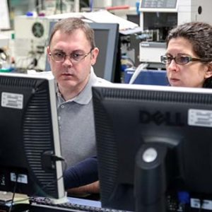 man and woman sitting at computers man and woman sitting at computers