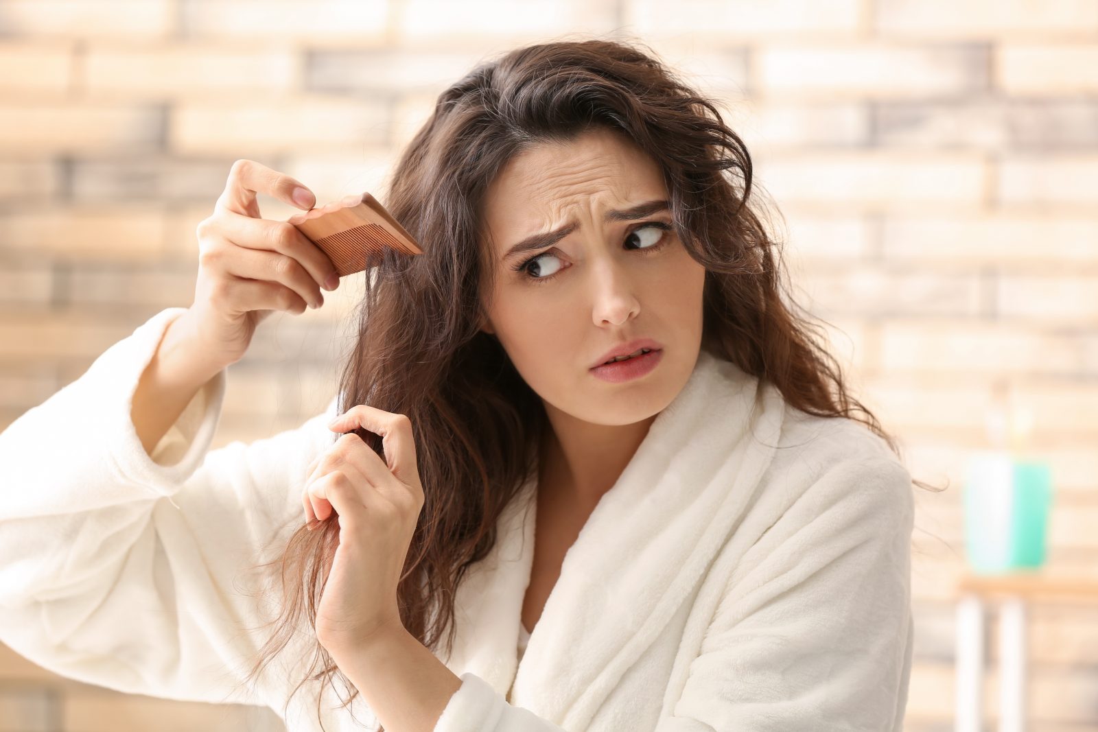 Woman with hair loss problem in bathroom.