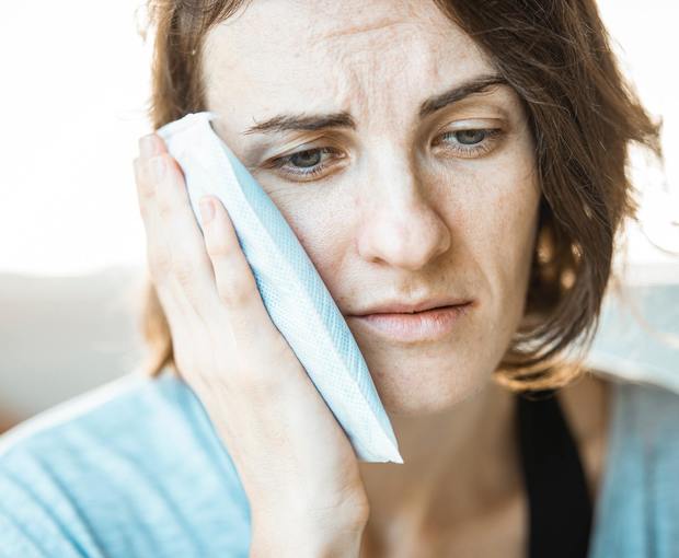 Femme avec de la douleur à la mâchoire