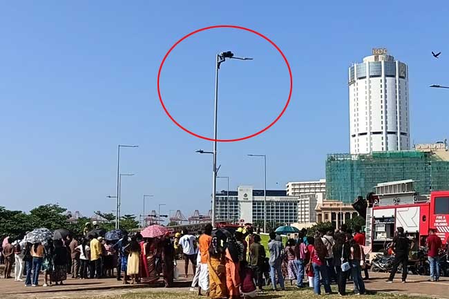 පොලීසියට එරෙහිව පුද්ගලයෙක් විදුලි කණුවකට නැග විරෝධයක 