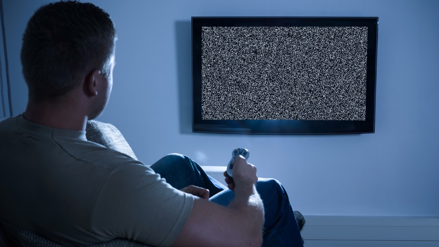 Man Sitting On Couch Watching Soccer Game On Television At Home