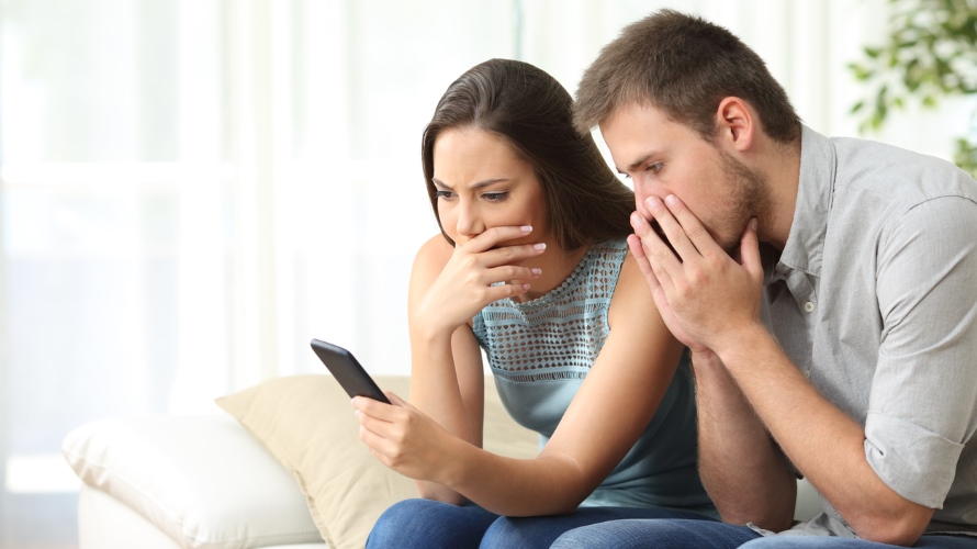 Worried couple reading bad news on the phone