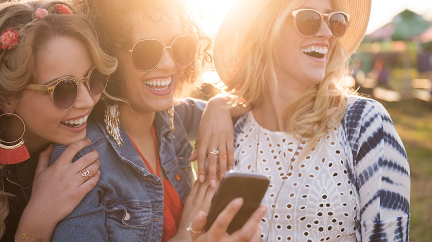brand-experience-social-media-content-2019 Three women pose together; the middle woman is showing the rest of the crowd is looking at what she is showing them