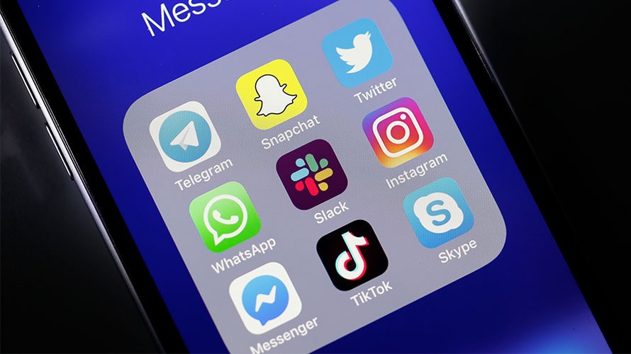 messaging-clutter-content-2019 the screen of an iPhone; a folder is open revealing social media Apps like telegram, snapchat, twitter, whatsapp, slack, instagram, messenger, tiktok, and skype