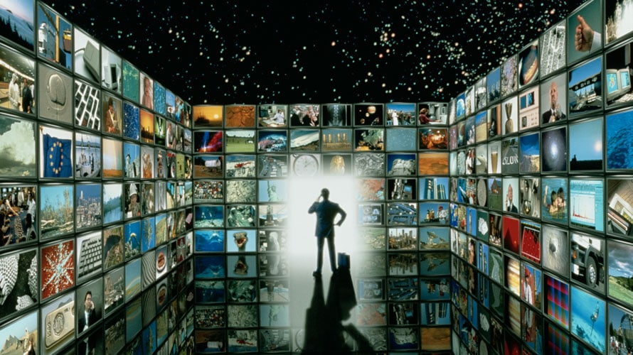 see-upfronts-CONTENT-2019 A man is standing; around him are screens on each side of him; on the massive screens there are pictures from throughout history like the moon landing
