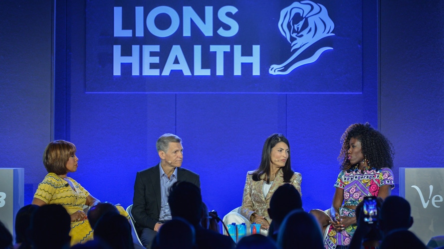 marketers-habit-change-cannes-CONTENT-2019 four marketers are seen talking on a stage at an event that says Lions Health at Cannes