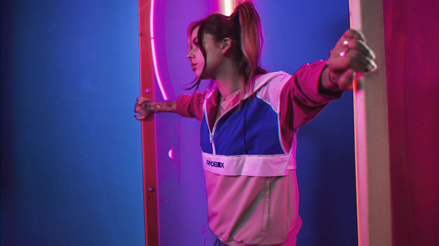 Female model wearing Andbox pullover with arms spread across the room