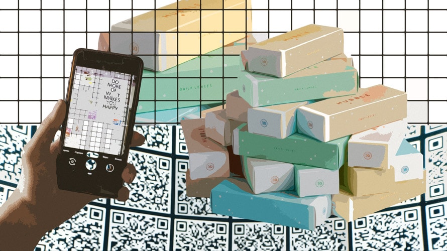 brand-connected-packaging-CONTENT-2019 A pile of bars of soaps and someone holding a phone up in front of them.