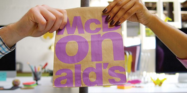 mcdonalds-wkny-2-page-2019 Two different hands hold a McDonald's bag.