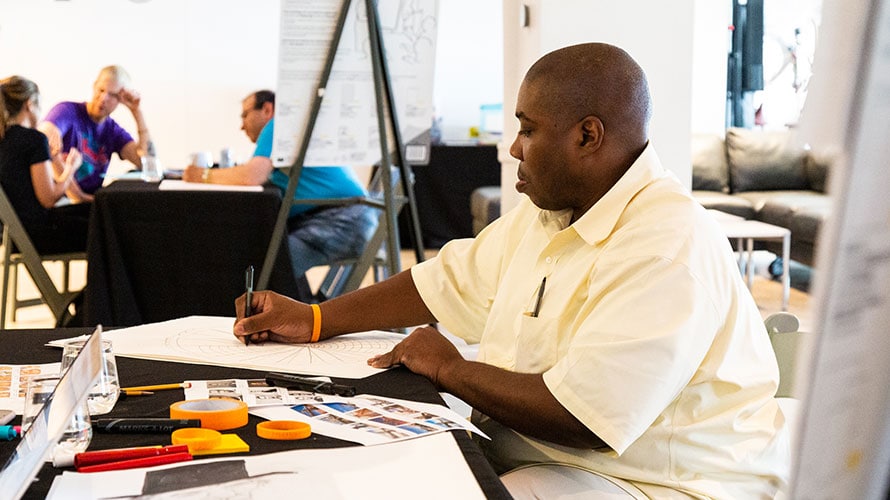 OneClub-RockOnGoWild-content-2019 Man drawing at a table with art supplies