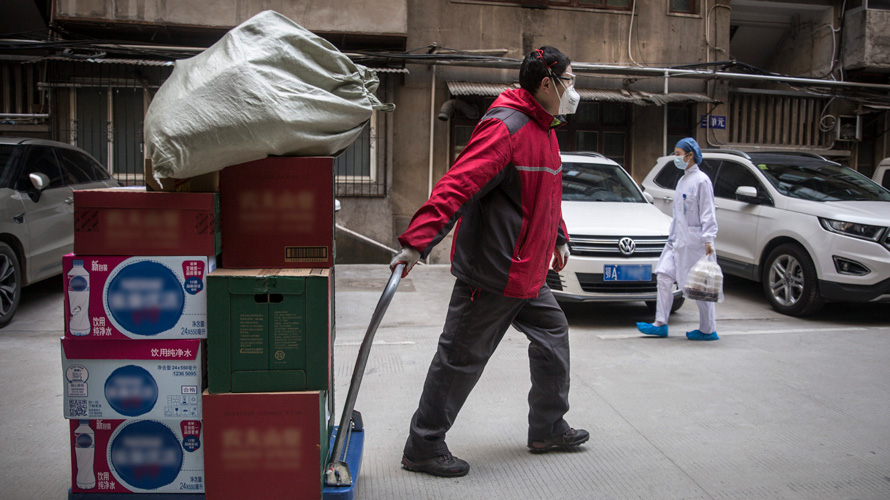 coronavirus-retail-china-CONTENT-2020 A man with a mask on moving boxes of products