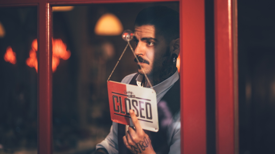ManWithMustacheHangingClosedSign