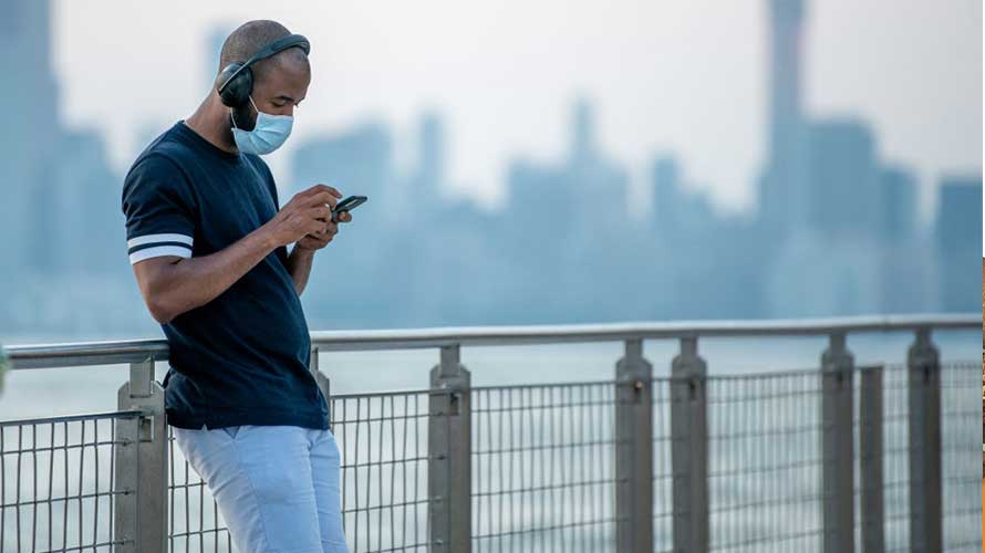 podcast-ad-revenue-CONTENT-2020 a man leaning on a railing looking at a phone