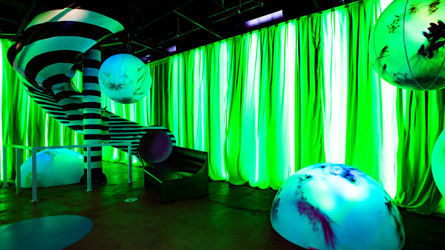 neon green lit walls with a curved slide
