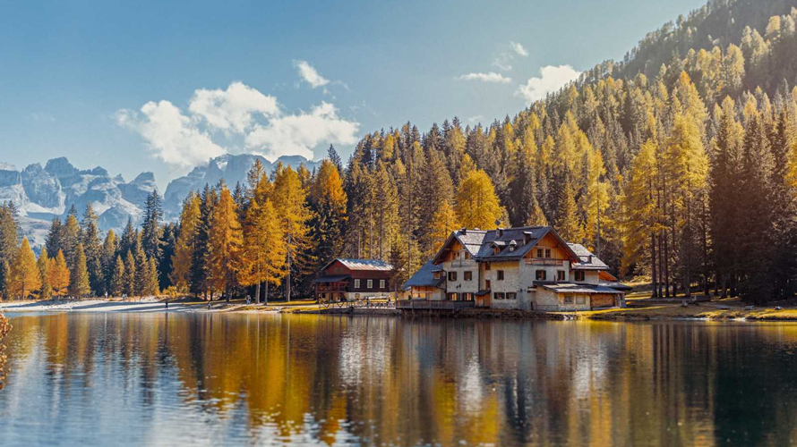 flexcationer-remote-work-class-CONTENT-2020 a picturesque view on a home on a lake amid trees and mountains