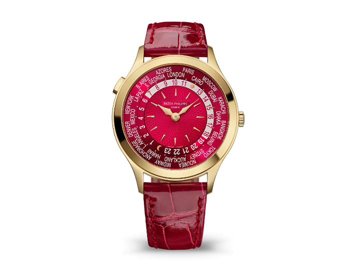Patek Philippe World Time ref. 7129J-001 featuring a self-winding mechanical movement, hand-guilloched red dial, and a 36mm 18k yellow gold case on an alligator strap with a prong buckle.