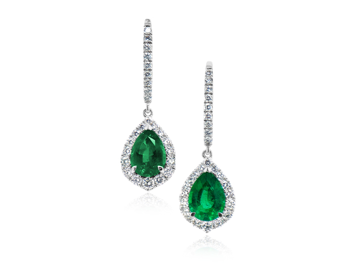 Pear shape emerald and round brilliant cut diamond earrings in 18k white gold.