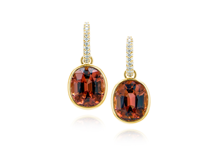 Oval peach tourmaline and round brilliant cut diamond earrings in 18k yellow gold.