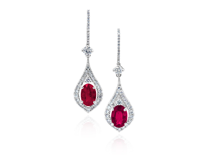 Oval ruby and round brilliant cut diamond earrings in 18k white gold.