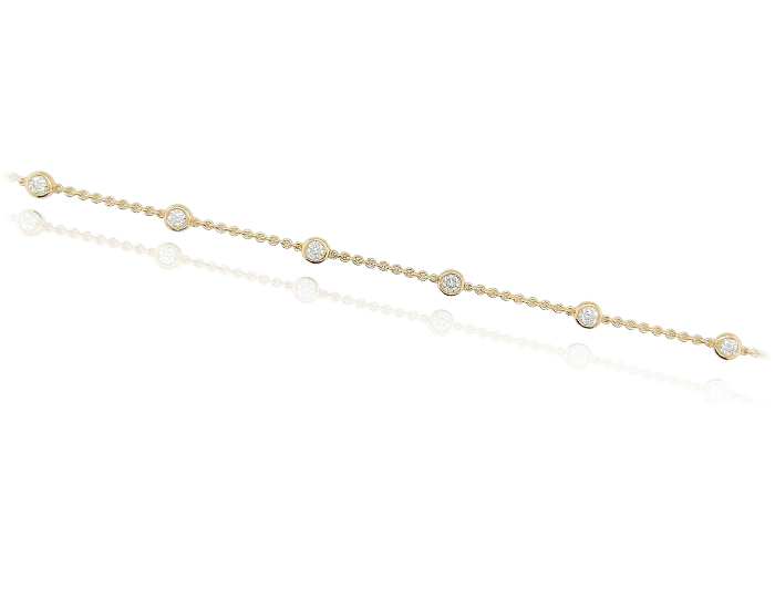 Round brilliant cut bezel bracelet in 18k yellow gold.