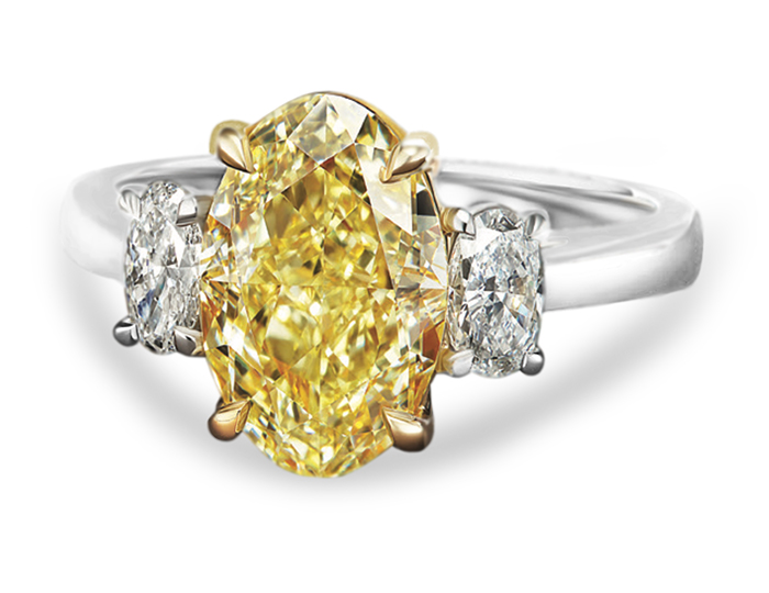 Fancy light yellow diamond and oval cut diamond engagement ring in 18k yellow gold and platinum.