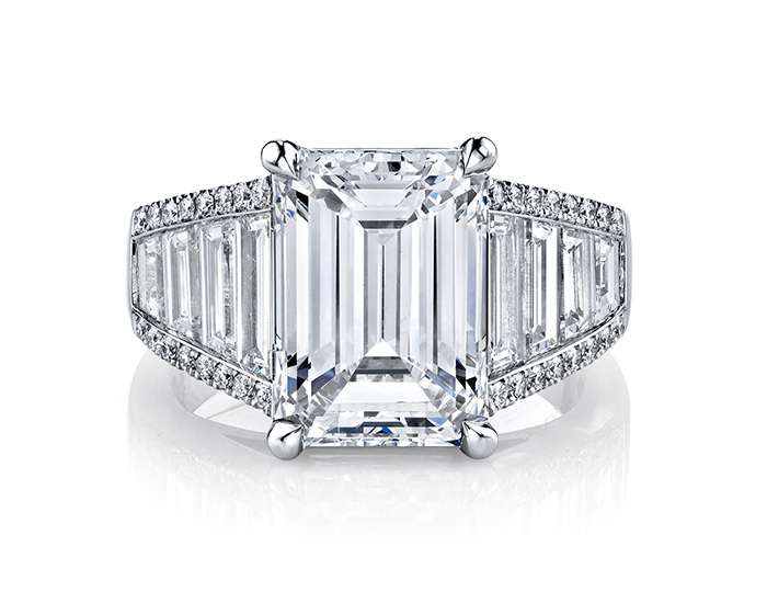 Emerald, trapezoid, and round brilliant cut diamond engagement ring in platinum.