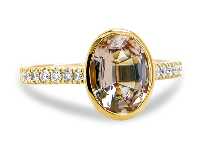 Oval cut morganite and round brilliant cut diamond ring in 18k yellow gold.