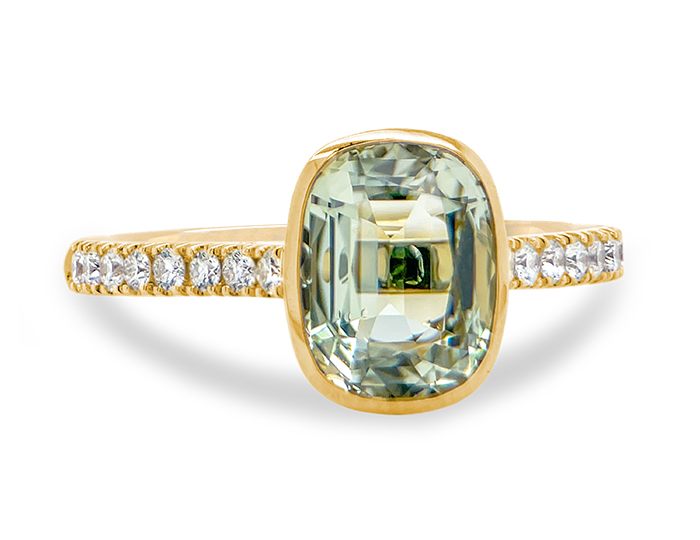Cushion cut prasolite and round brilliant cut diamond ring in 18k yellow gold.