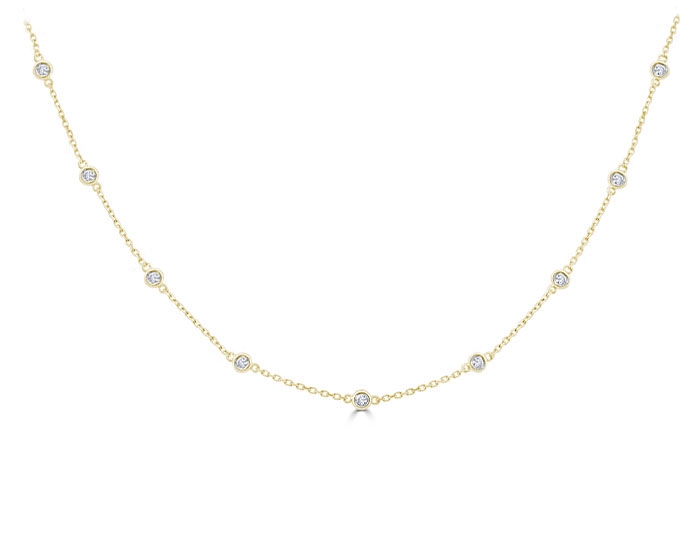 Round brilliant cut diamond bezel necklace in 18k yellow gold.