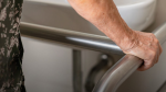 hand of an older woman on a metal bar